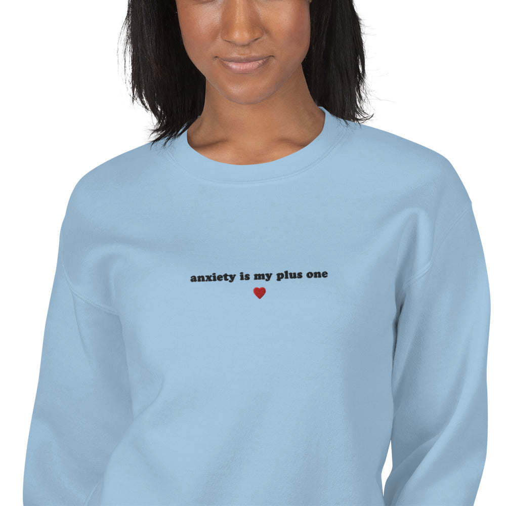 Cozy embroidered unisex crewneck in light blue with 'anxiety is my plus one' design, perfect for self-expression and mental health awareness.