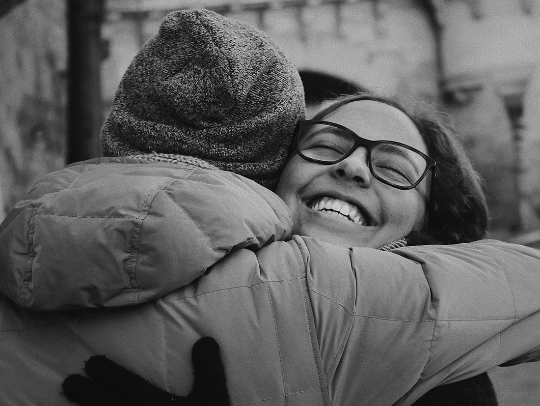 two persons hugging and laughing