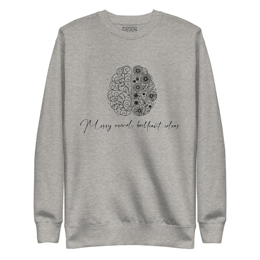 Carbon grey unisex premium sweatshirt featuring a sleek illustration of a brain with flowers blooming from it. The text 'Messy Mind, Brilliant Ideas' is written in a delicate script underneath the design, symbolizing creativity emerging from chaos.